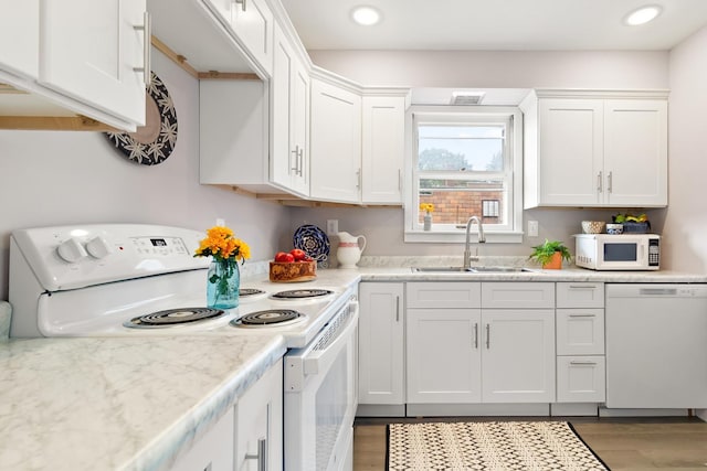 kitchen featuring white cabinetry, sink, and white appliances