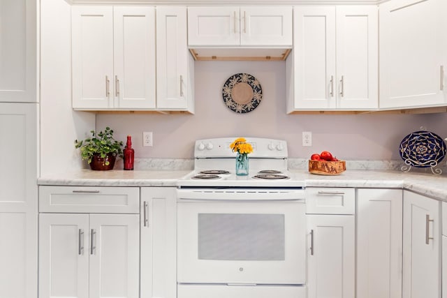 kitchen featuring white cabinetry, white electric range oven, and light stone countertops