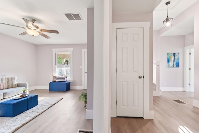 sitting room with ceiling fan and light wood-type flooring