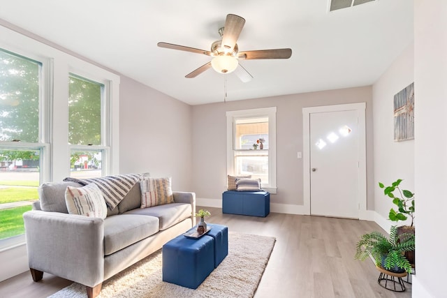 living room featuring ceiling fan and light hardwood / wood-style flooring