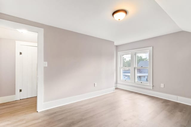 unfurnished room with lofted ceiling and light hardwood / wood-style flooring