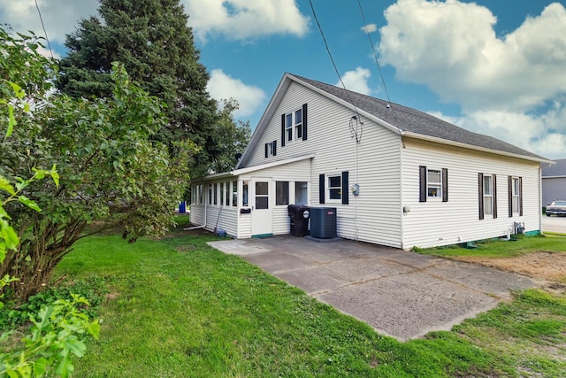 view of home's exterior with a yard, central AC, and a sunroom