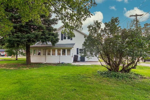 rear view of property featuring a yard and a patio area