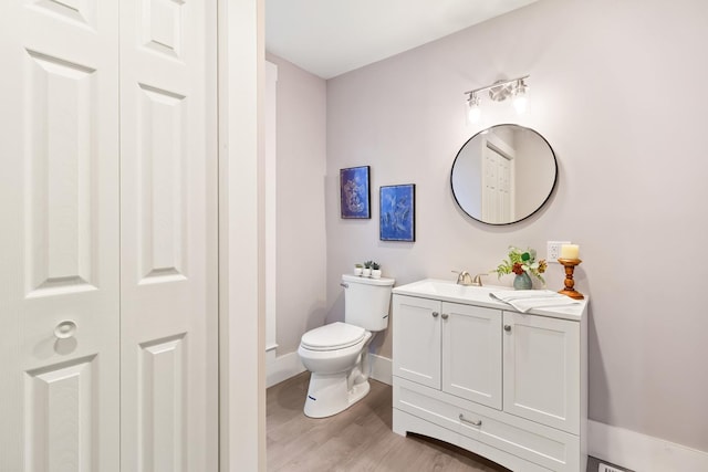 bathroom featuring vanity, wood-type flooring, and toilet