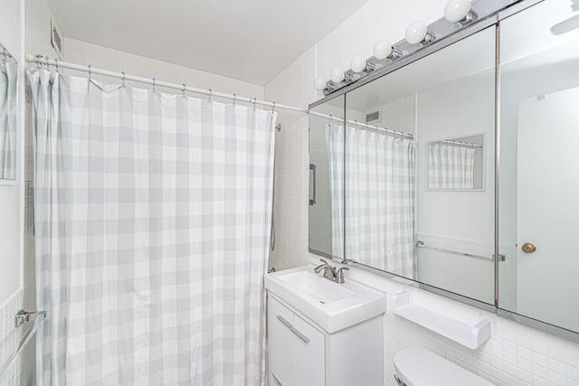 bathroom featuring toilet, walk in shower, and vanity