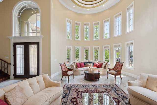 living room with crown molding, french doors, and a towering ceiling