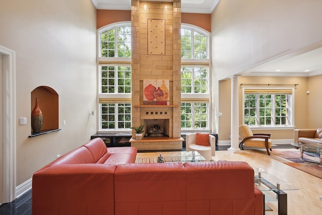 living room featuring a fireplace, a wealth of natural light, a high ceiling, and hardwood / wood-style floors