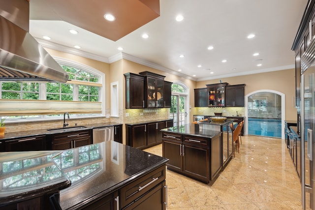 kitchen featuring dark brown cabinets, a kitchen island, dishwasher, and dark stone counters