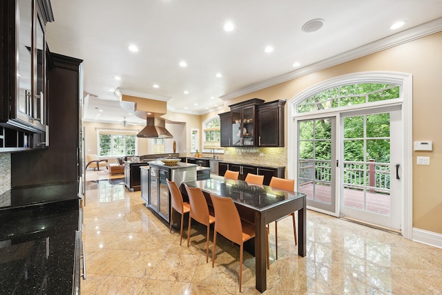 dining space with light tile patterned floors, a healthy amount of sunlight, and crown molding