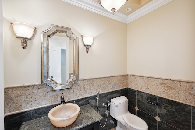 bathroom featuring tile walls, ornamental molding, vanity, and toilet