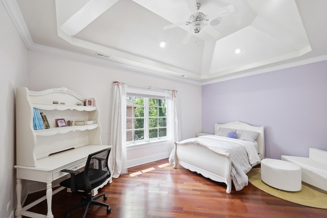 bedroom with ceiling fan, a tray ceiling, ornamental molding, and hardwood / wood-style floors