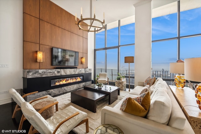 living room featuring an inviting chandelier, hardwood / wood-style flooring, expansive windows, and a high ceiling