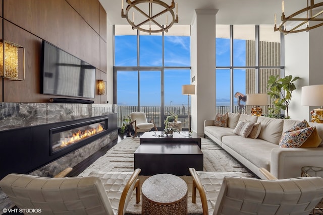 living room featuring ornamental molding, a towering ceiling, hardwood / wood-style floors, and a notable chandelier