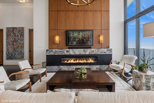 dining space featuring crown molding, a wall of windows, a towering ceiling, dark hardwood / wood-style flooring, and a chandelier