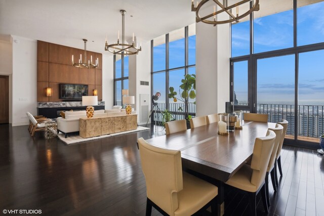 living room featuring expansive windows, a chandelier, and a high ceiling