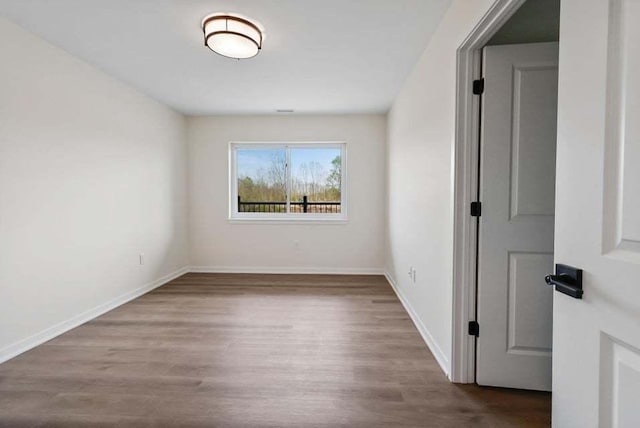 empty room with baseboards and wood finished floors