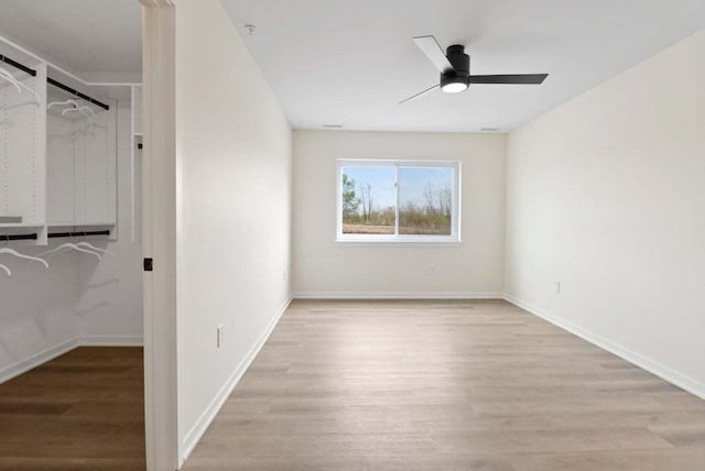 unfurnished bedroom featuring light wood finished floors, ceiling fan, and baseboards