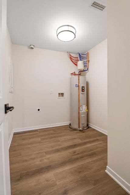 washroom with dark wood finished floors, visible vents, water heater, electric dryer hookup, and laundry area