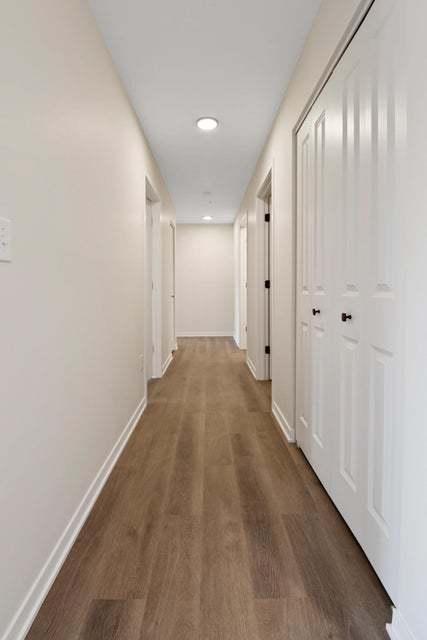 corridor with recessed lighting, dark wood-style flooring, and baseboards