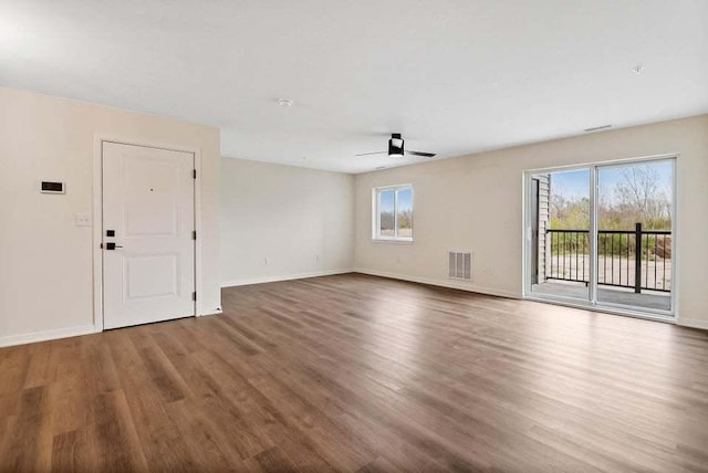 unfurnished living room with ceiling fan, wood finished floors, visible vents, and baseboards