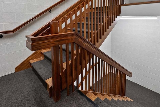 stairway featuring concrete block wall