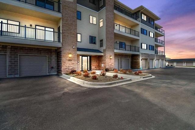 property at dusk featuring a garage and driveway