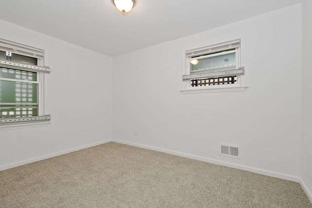 carpeted spare room featuring a wealth of natural light