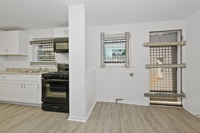 kitchen featuring white cabinets, a healthy amount of sunlight, light hardwood / wood-style floors, and black appliances