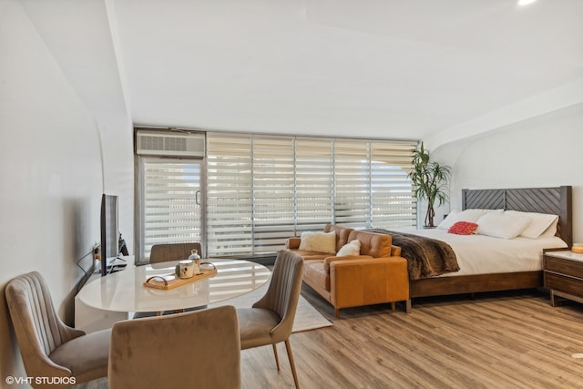 bedroom featuring a wall unit AC and hardwood / wood-style flooring