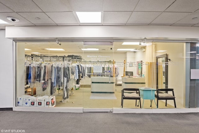 exercise room featuring a drop ceiling and carpet