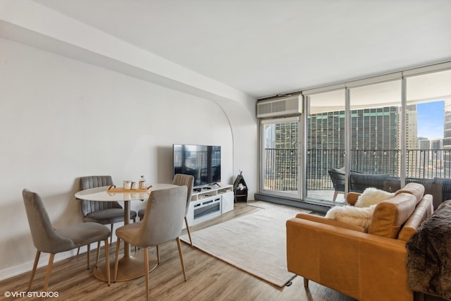 living room with a wall of windows, light hardwood / wood-style flooring, and a wealth of natural light