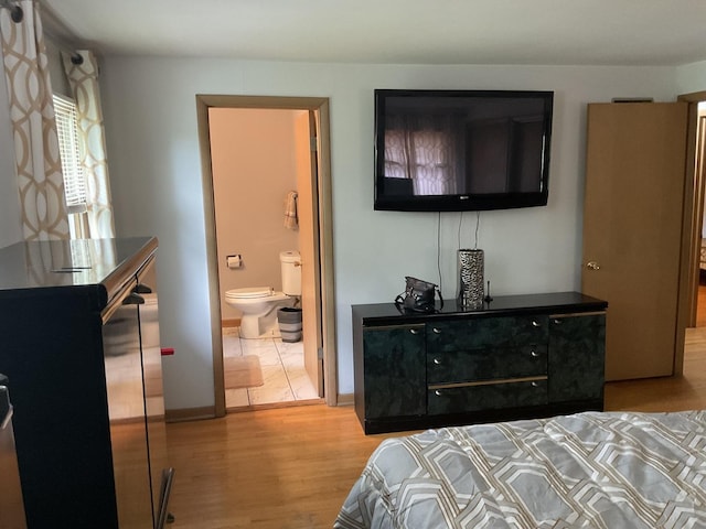 bedroom featuring ensuite bathroom and light hardwood / wood-style floors