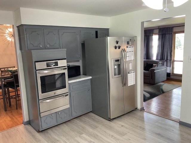 kitchen featuring appliances with stainless steel finishes, gray cabinets, and light hardwood / wood-style flooring