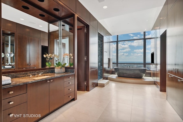 full bathroom with recessed lighting, vanity, a freestanding bath, tile patterned floors, and a wall of windows