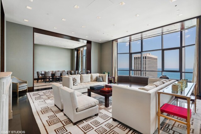 living room with plenty of natural light, a water view, and floor to ceiling windows