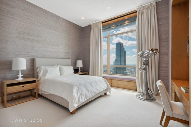 carpeted bedroom featuring a view of city and wallpapered walls