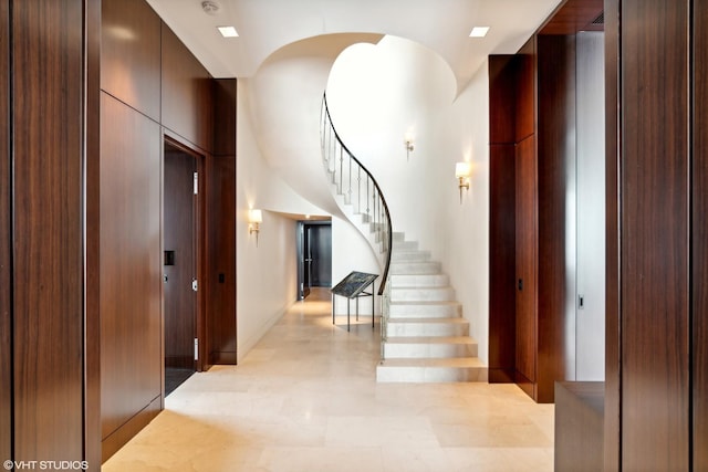 foyer featuring stairs and arched walkways