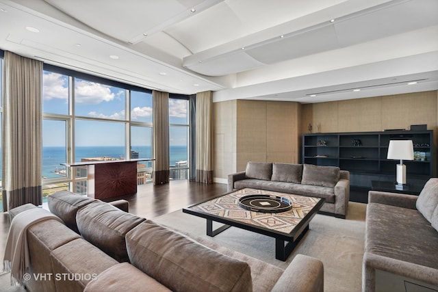 living area featuring a water view, expansive windows, wood finished floors, and recessed lighting