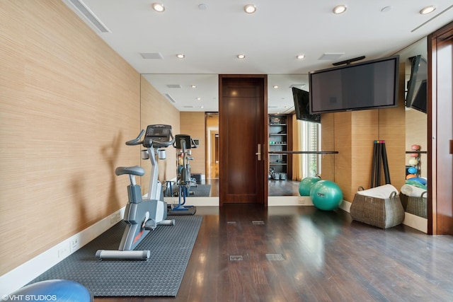 exercise area with baseboards, wood finished floors, and recessed lighting