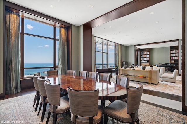 dining area with plenty of natural light, wood finished floors, and a water view