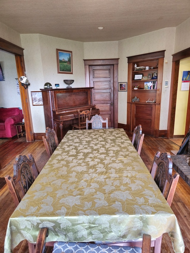 dining area with built in shelves and dark hardwood / wood-style flooring