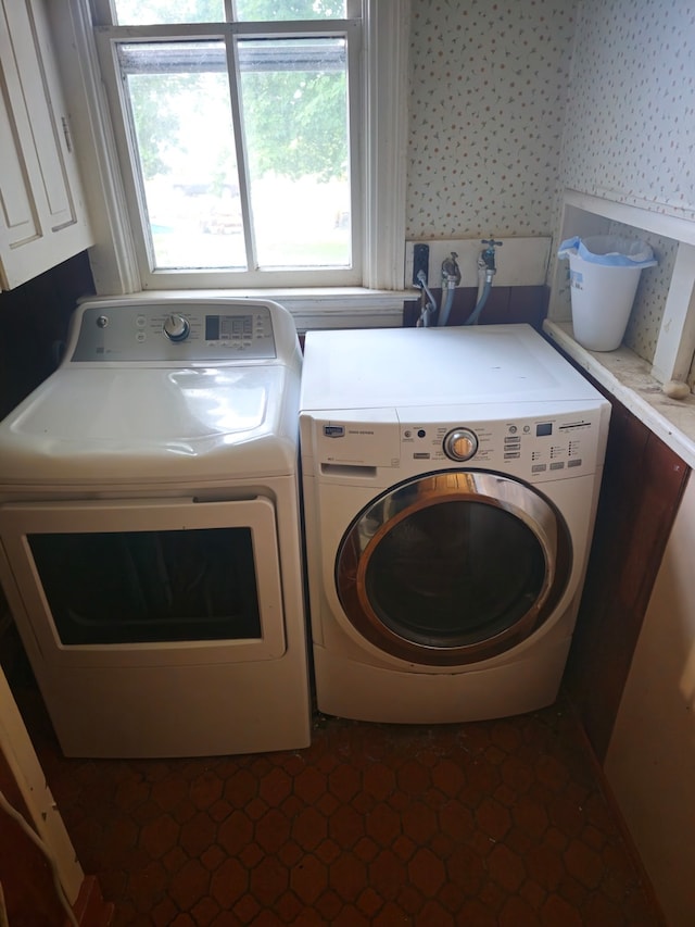 laundry room featuring washing machine and dryer and dark tile patterned flooring