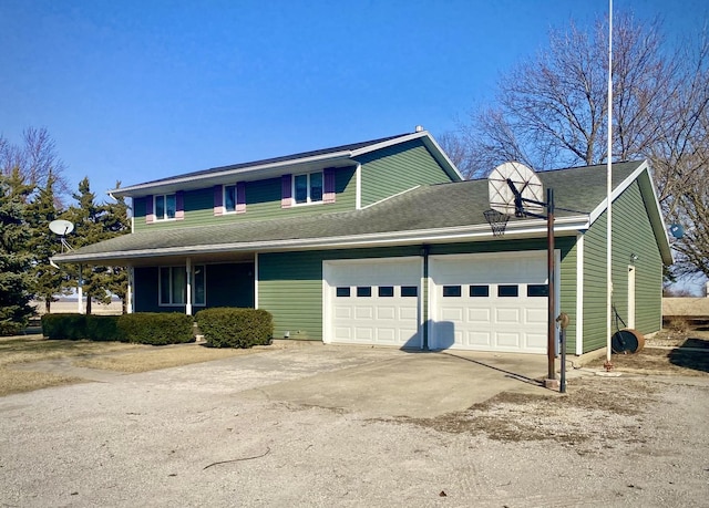 view of front of property with a garage, driveway, and roof with shingles