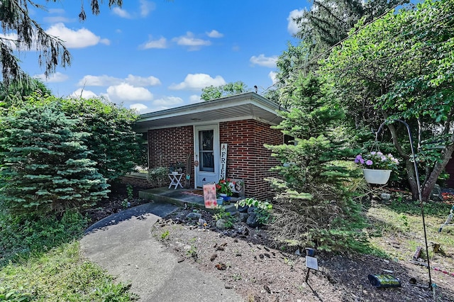 view of exterior entry featuring brick siding