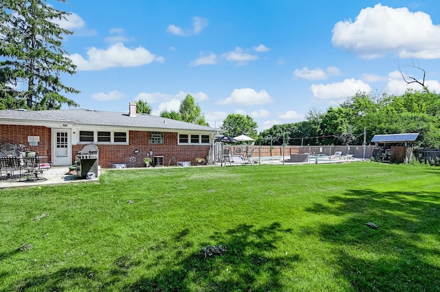 view of yard with a patio, central AC unit, and fence