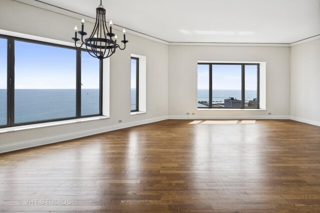 interior space with plenty of natural light, a water view, and wood-type flooring