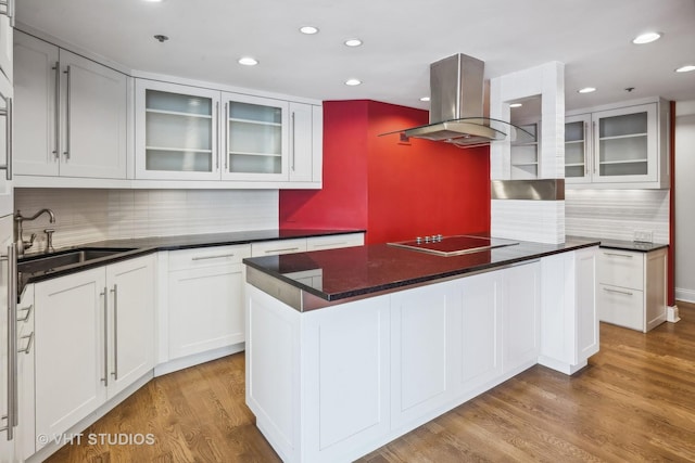 kitchen featuring sink, light hardwood / wood-style flooring, white cabinetry, island range hood, and black electric cooktop