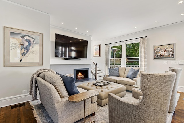 living room with wood finished floors, visible vents, and baseboards