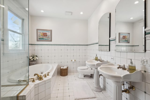 bathroom with recessed lighting, toilet, a sink, tile patterned flooring, and a whirlpool tub