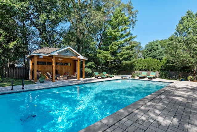 view of swimming pool featuring a fenced in pool, a fenced backyard, a patio, and ceiling fan